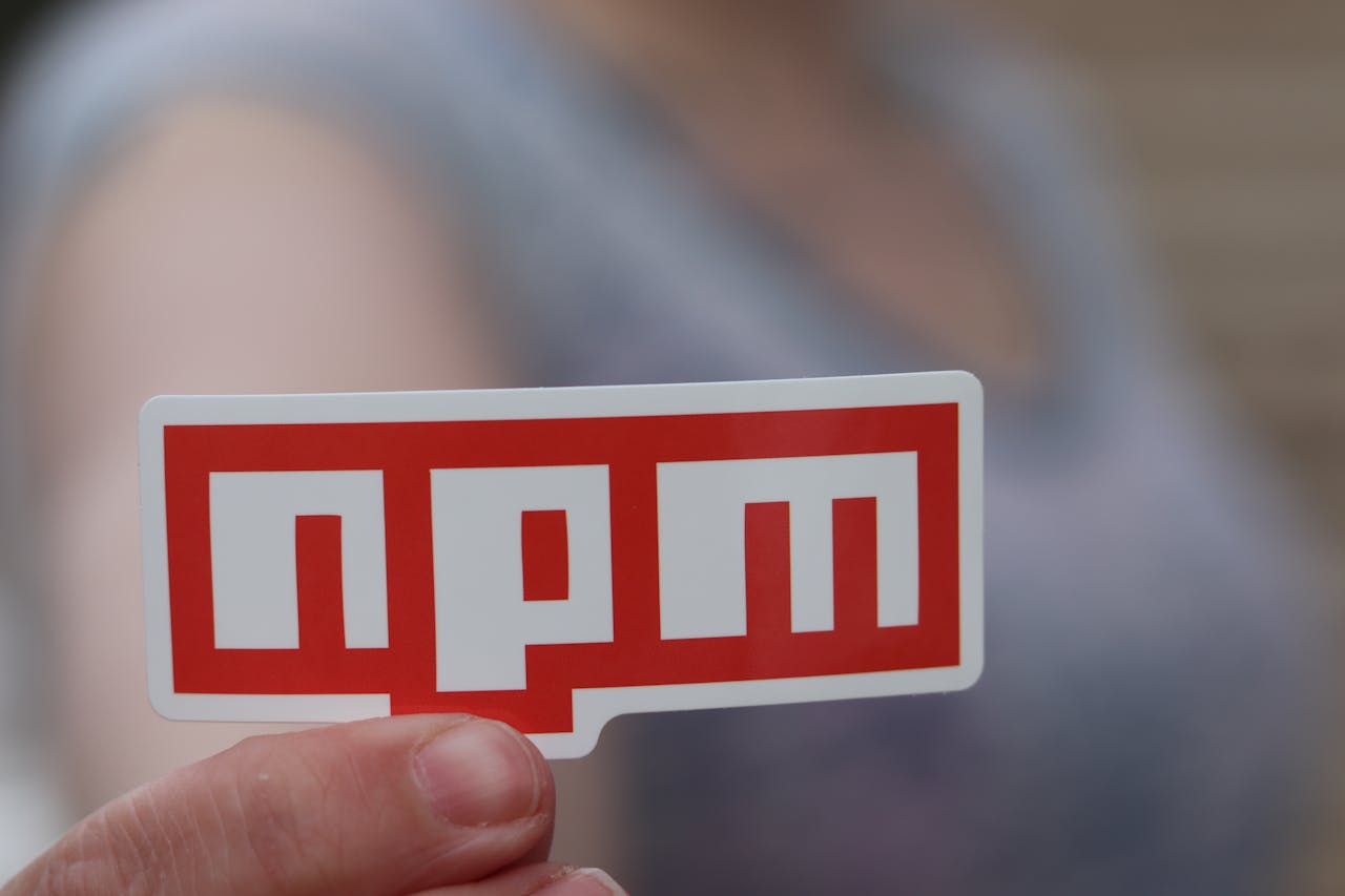 Le logo de npm tenu dans la main